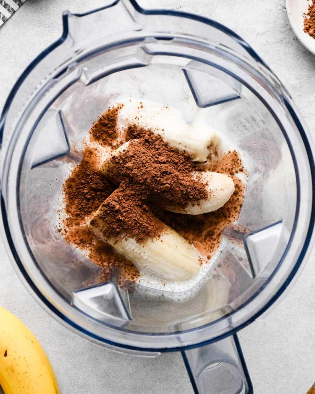 Using a blender tamper to safely push ingredients into the blades for smooth blending.