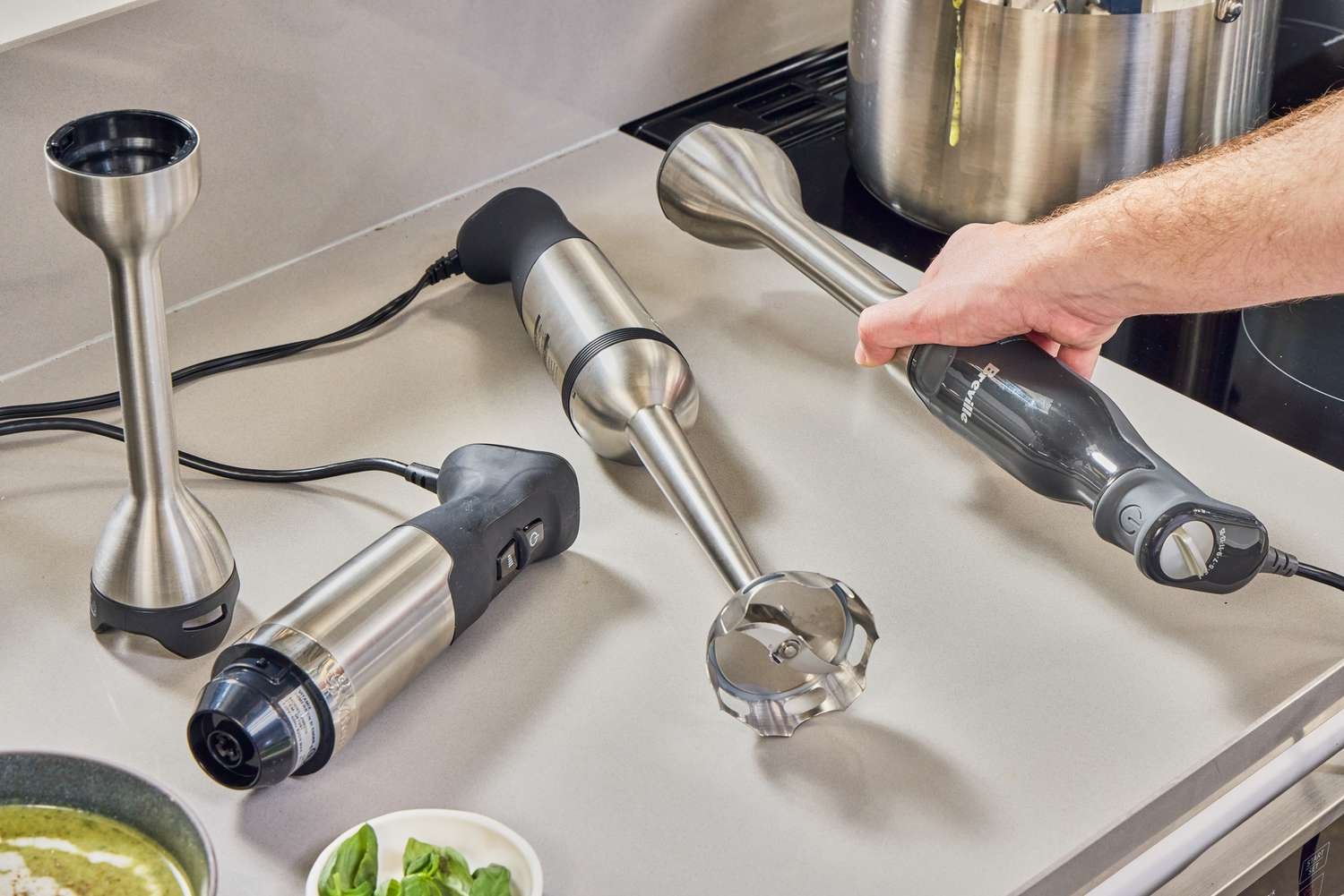 Hands carefully placing sliced fruit into a blender to prevent motor damage.