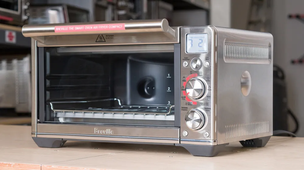 Air fryer basket removed beside shell showing small capacity