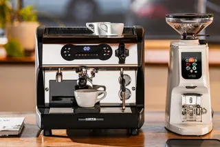Espresso machine, grinder, and scale on a wooden counter