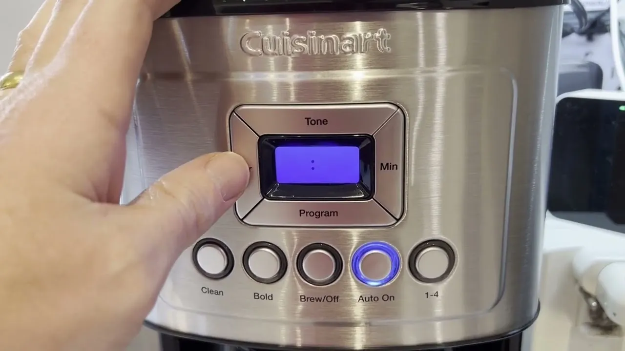 Finger pressing Program button to set Cuisinart coffee maker timer