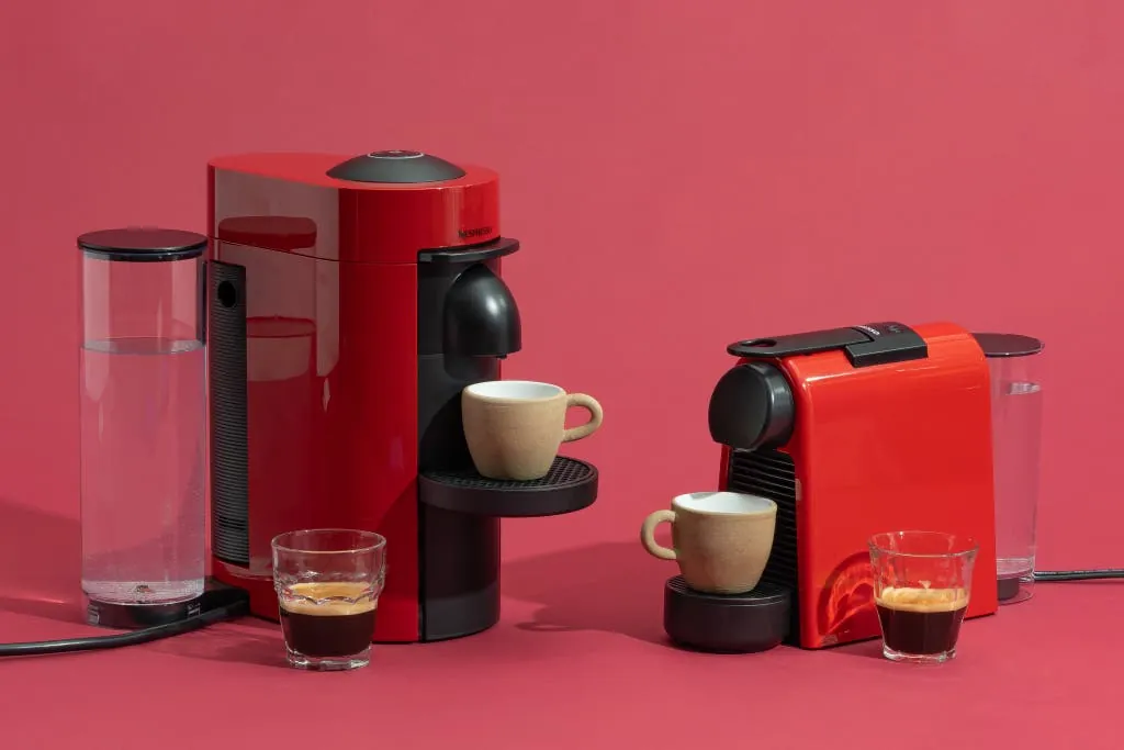 Hand comparing mismatched coffee capsules above a capsule machine