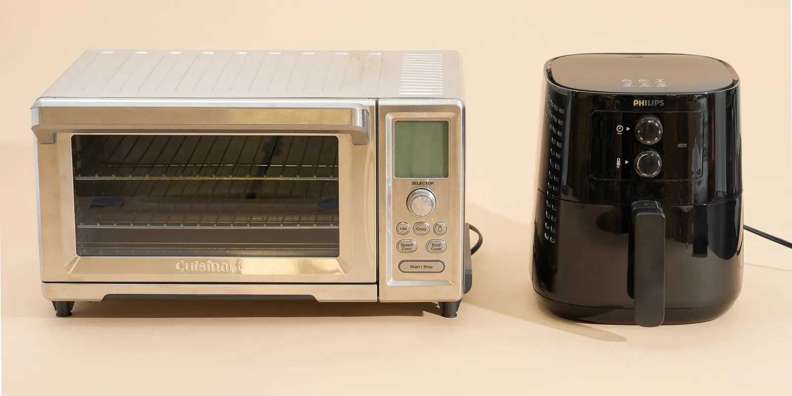 Small air fryer toaster oven beside a large wall oven and microwave